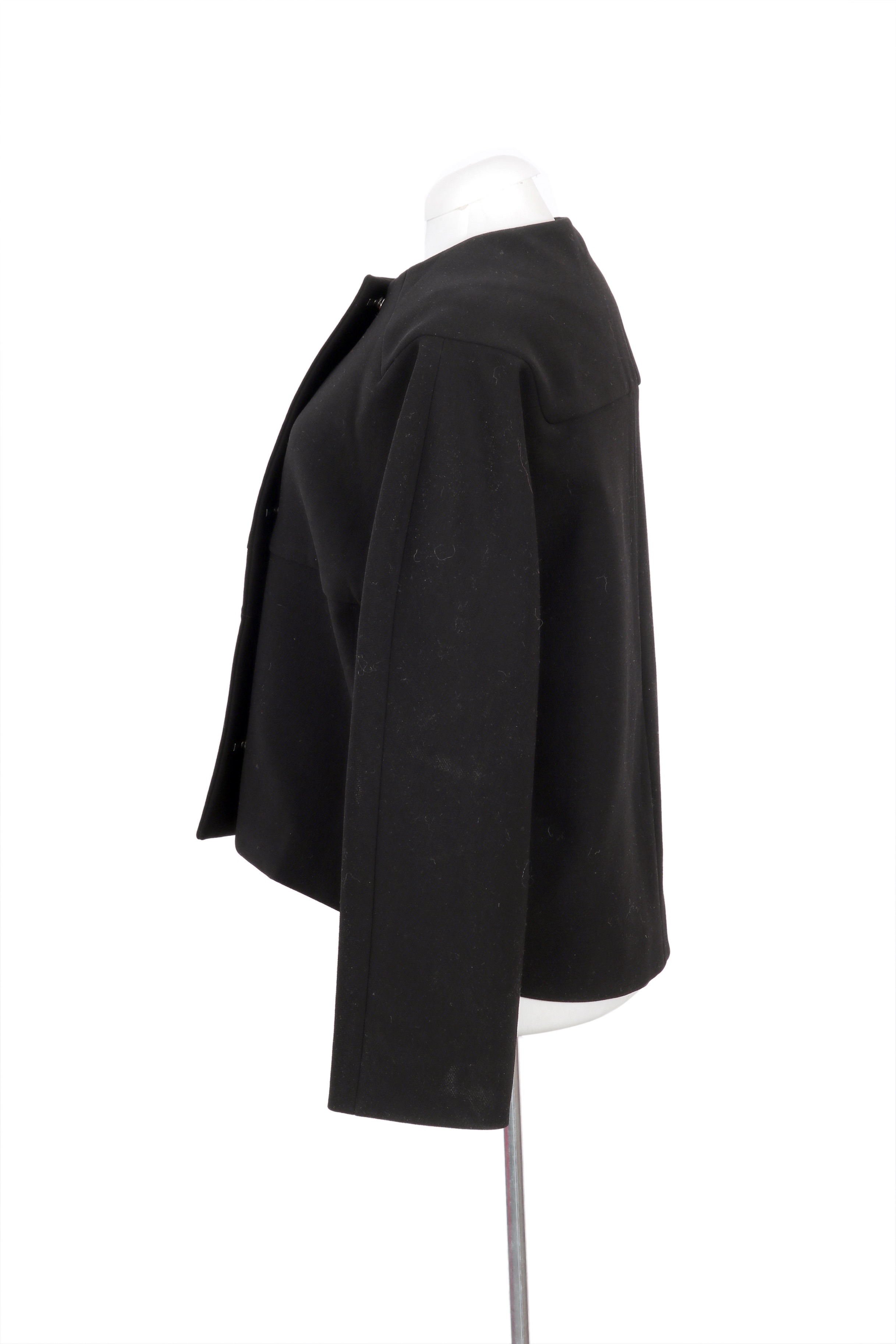 Balenciaga structured black jacket featuring a minimalist silhouette with sleek metal bar closures, offering a refined and modern look