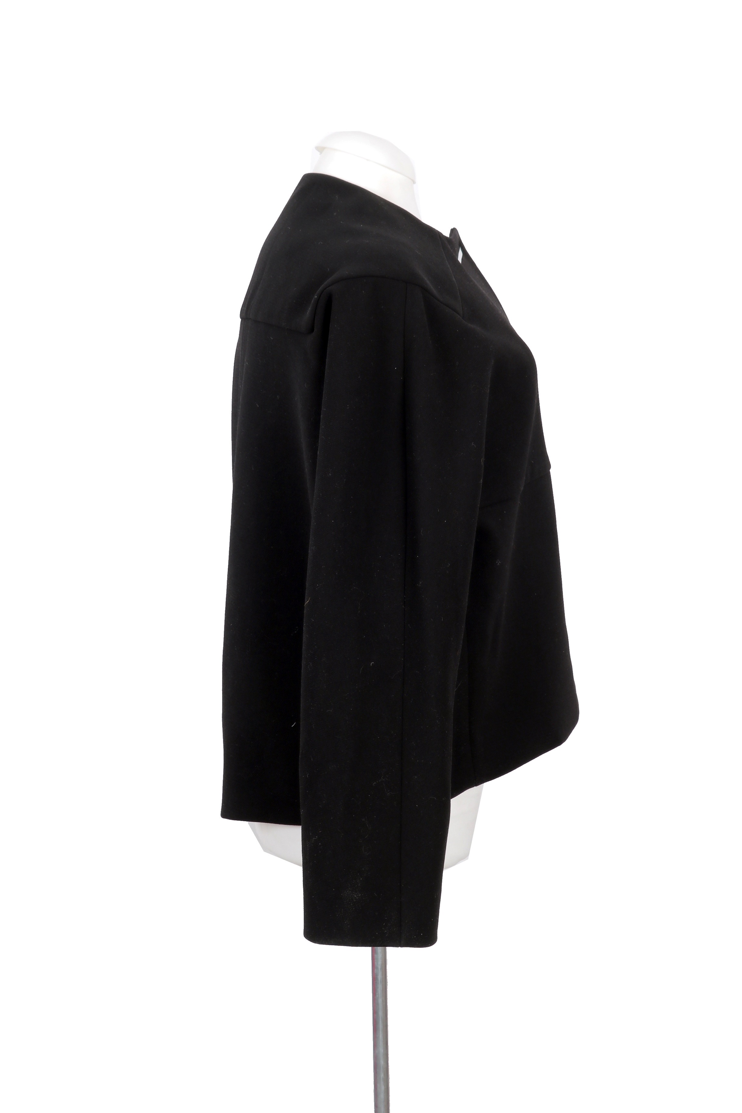 Balenciaga structured black jacket featuring a minimalist silhouette with sleek metal bar closures, offering a refined and modern look